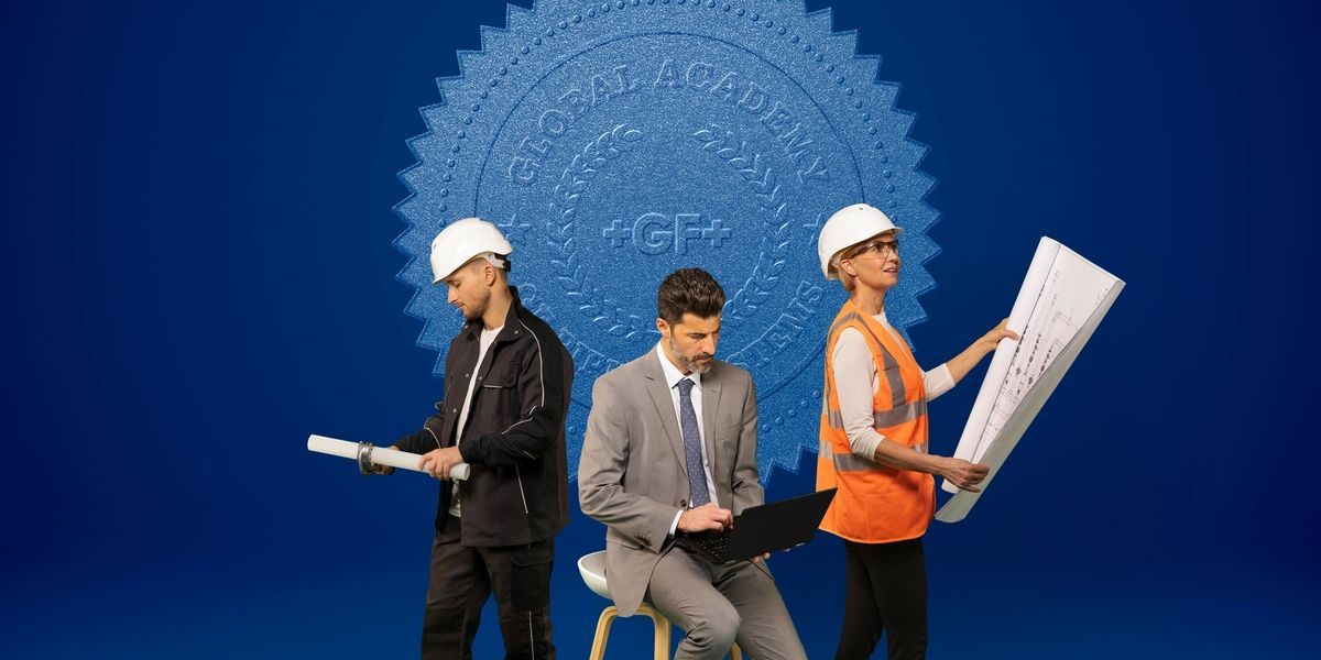 Engineers wearing helmets reviewing technical plans on site.